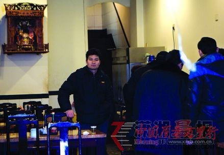 工作人員在忙著簽寫(xiě)整改通知書(shū),門(mén)店老板李明生站在身后一臉苦悶。圖/記者辜鵬博